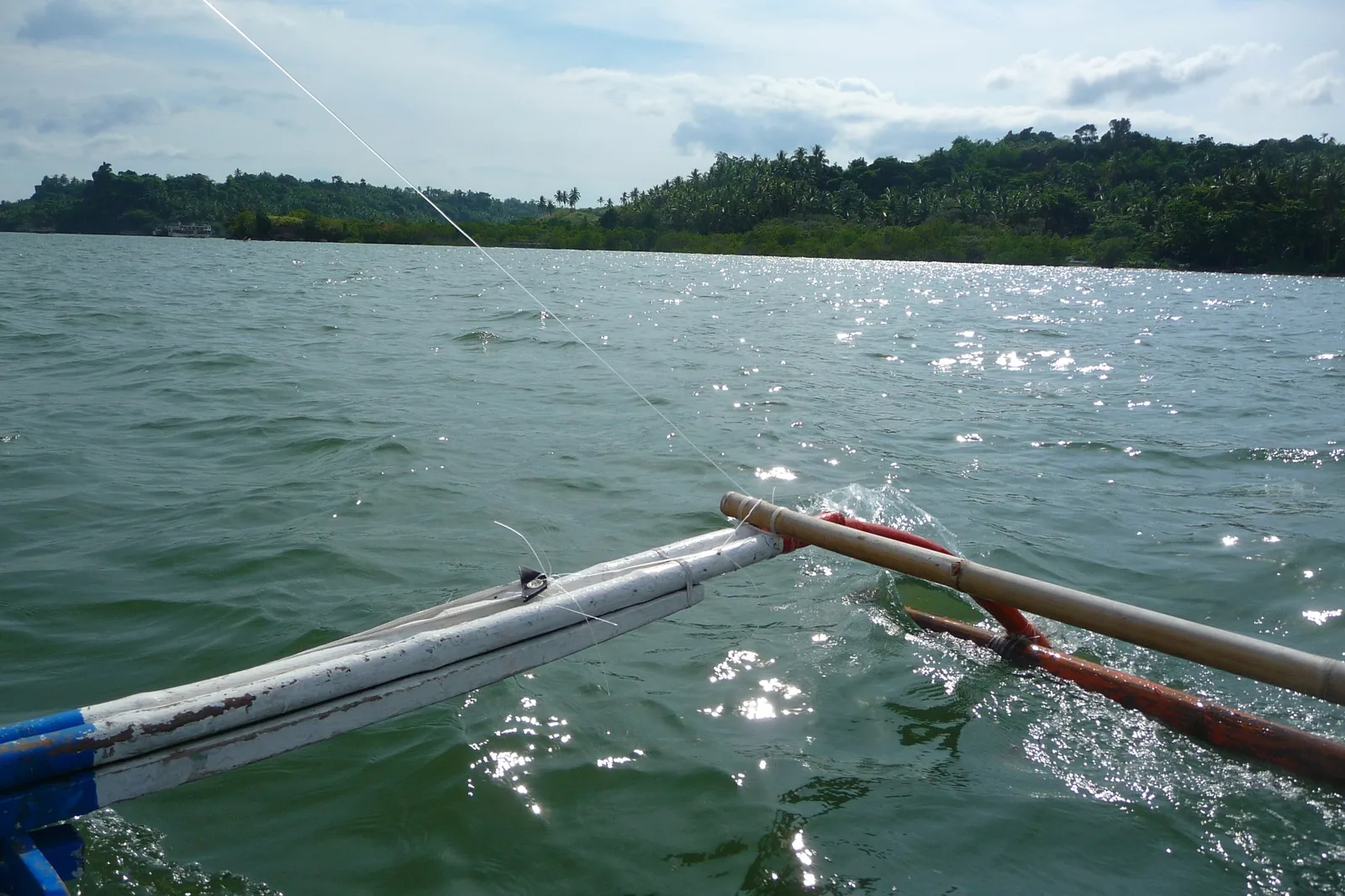 View from a traditional bangka approaching the tropical coast near Villa Kulintang